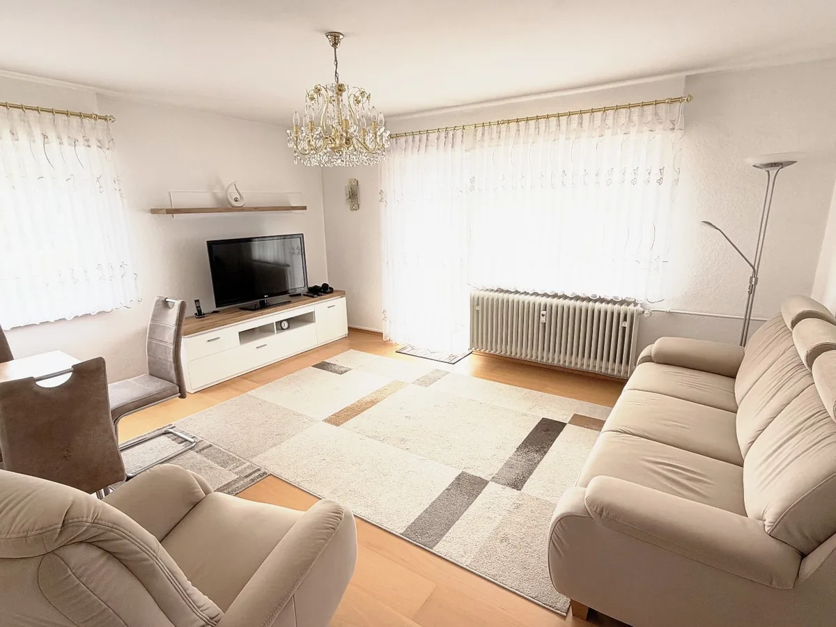 Aufgeräumtes, helles Wohnzimmer mit Sofa und Essplatz