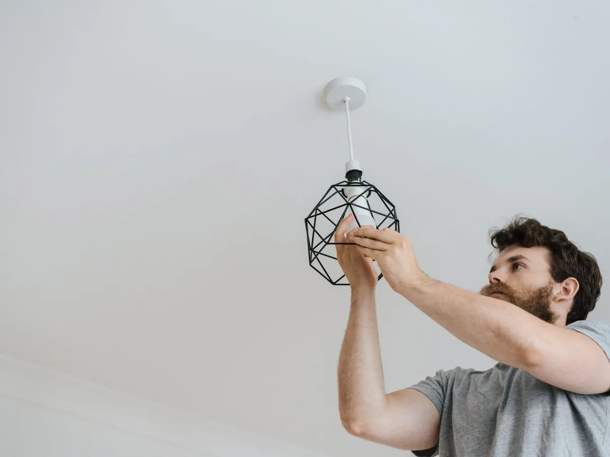 Handwerker montiert eine Deckenleuchte