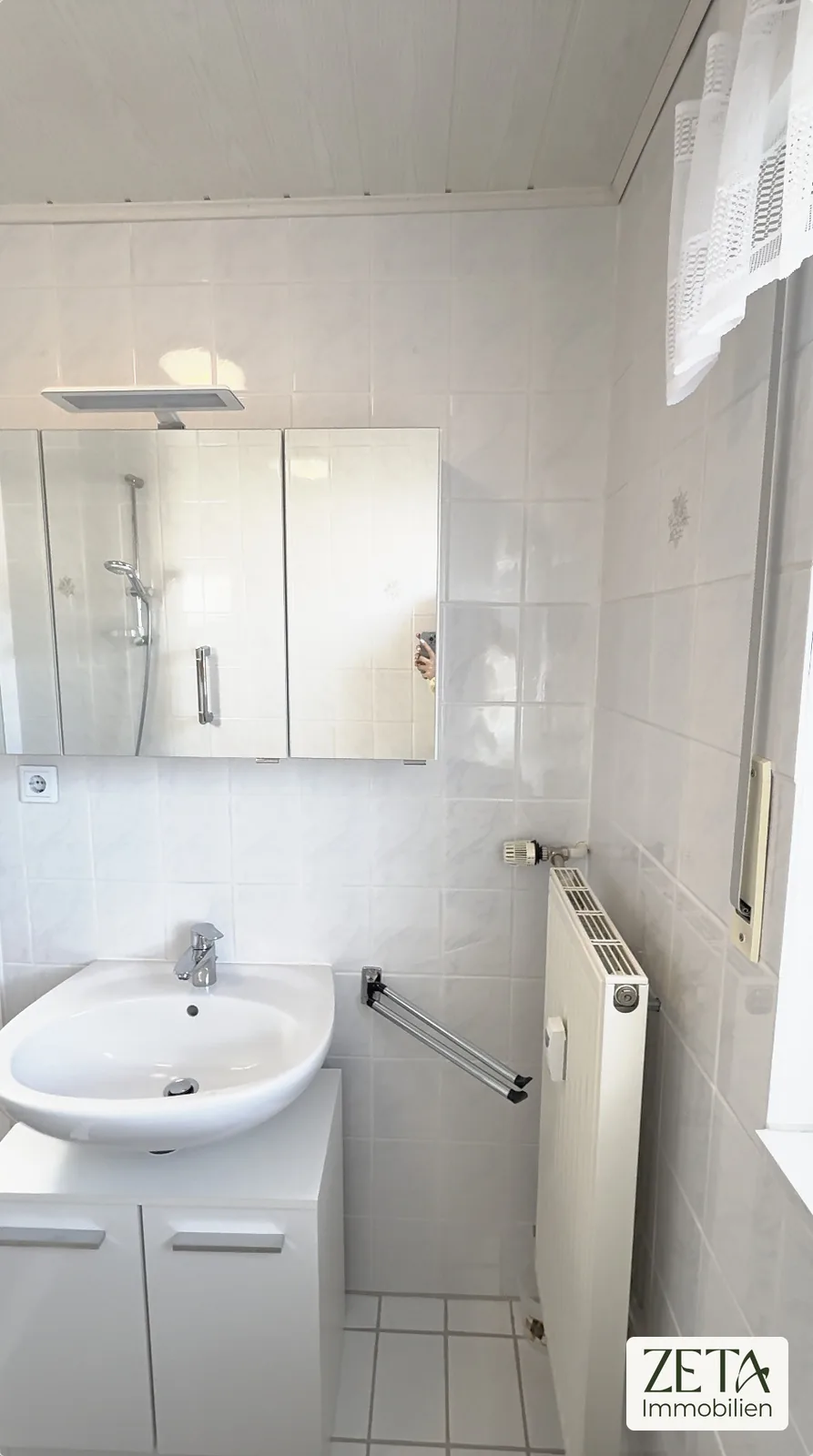 Badezimmer mit Waschtisch und Spiegelschrank