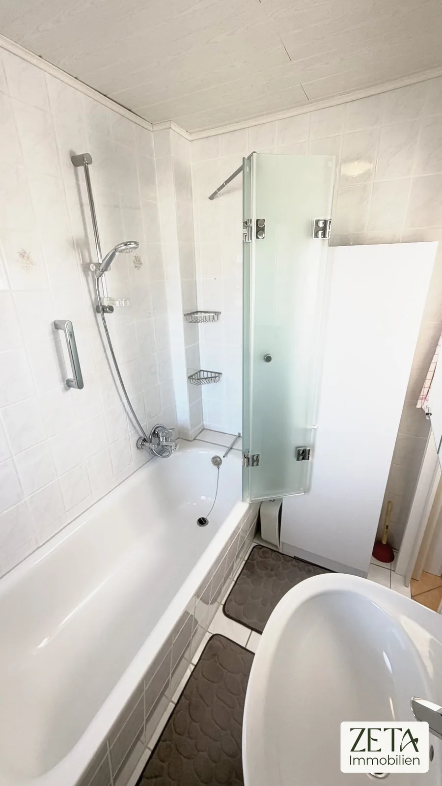 Badezimmer mit Wanne und Glas-Faltwand