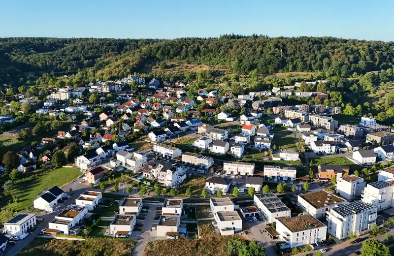 Luftaufnahme eines Neubaugebiets am Waldhang