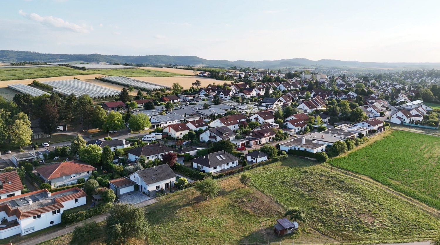 Luftaufnahme eines Wohngebiets am Ortsrand mit Feldern