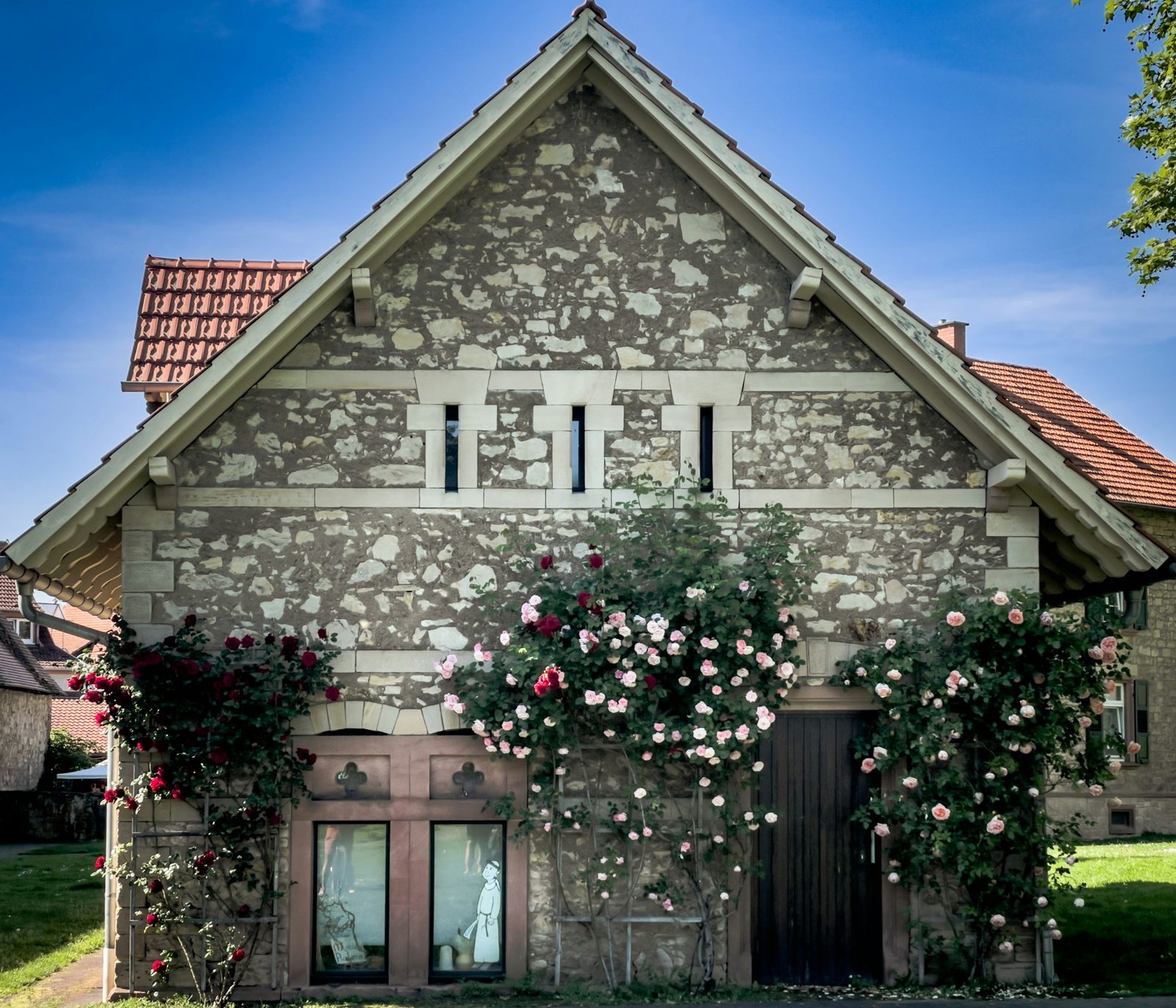 Steinhaus mit Kletterrosen an der Fassade