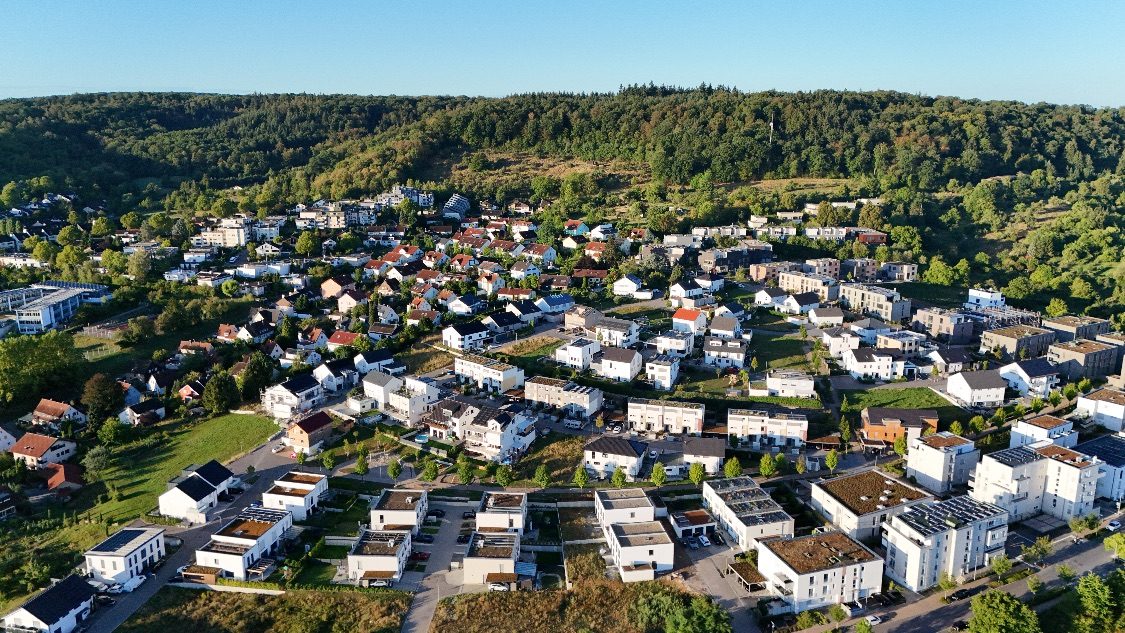 Luftaufnahme einer Neubausiedlung am Waldhang in der Region Heilbronn