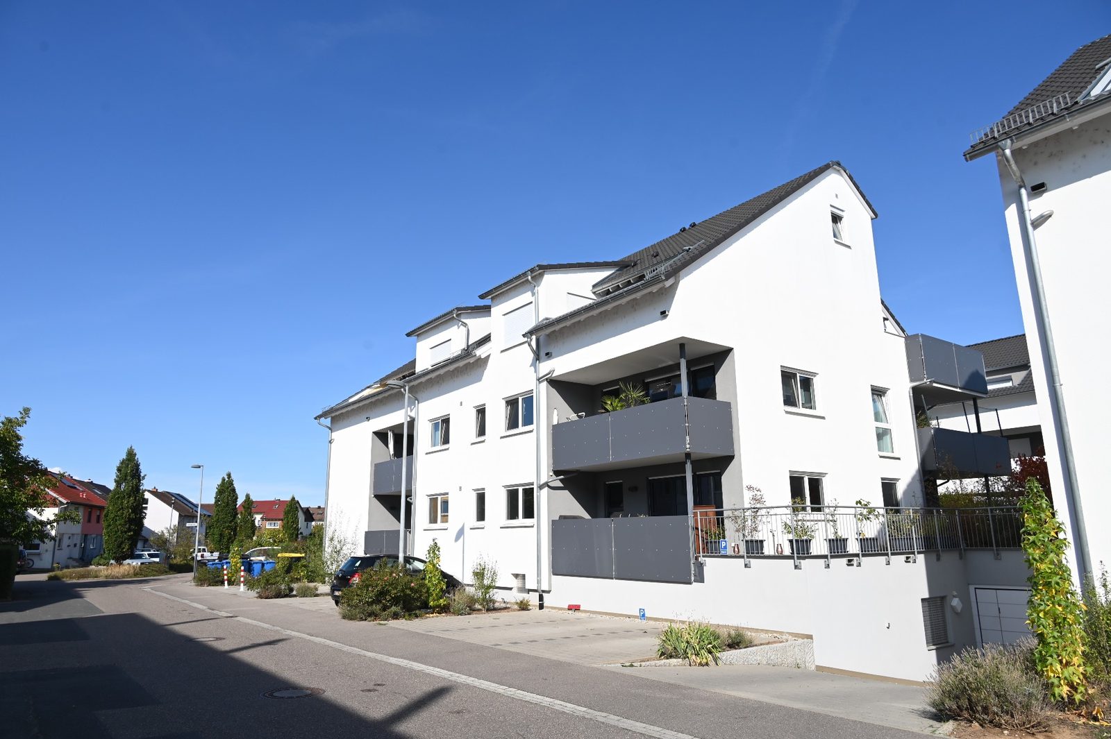 Neues Mehrfamilienhaus mit Balkonen an einer Wohnstraße